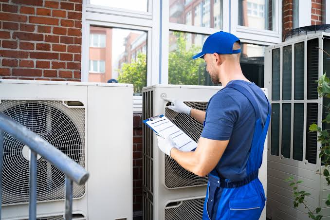 Technician inspecting an outdoor HVAC system for airflow performance