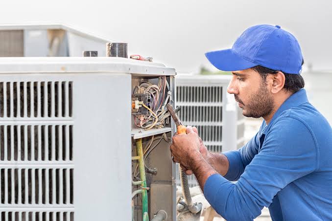 Technician servicing commercial HVAC condenser controls