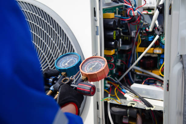 Technician servicing indoor heating and air conditioning equipment
