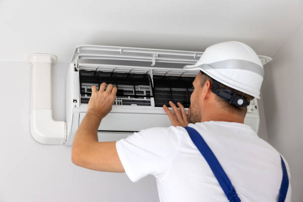 Technician completing preventative HVAC maintenance on an indoor unit
